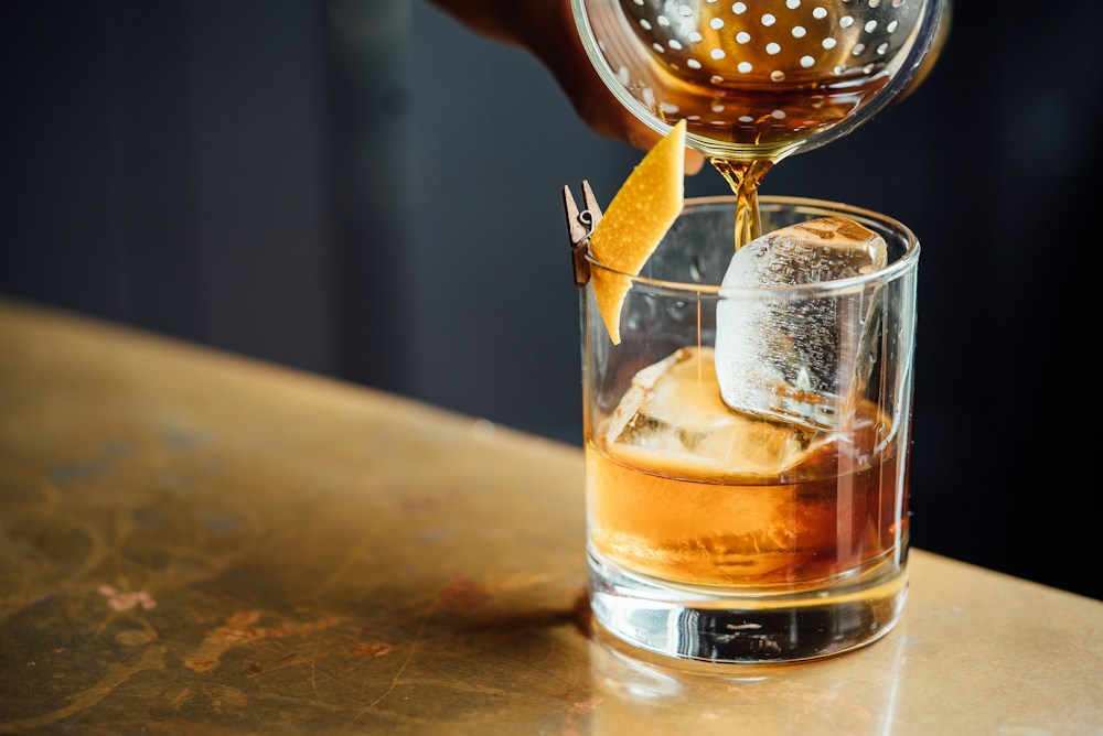A bartender pouring a drink into a glass